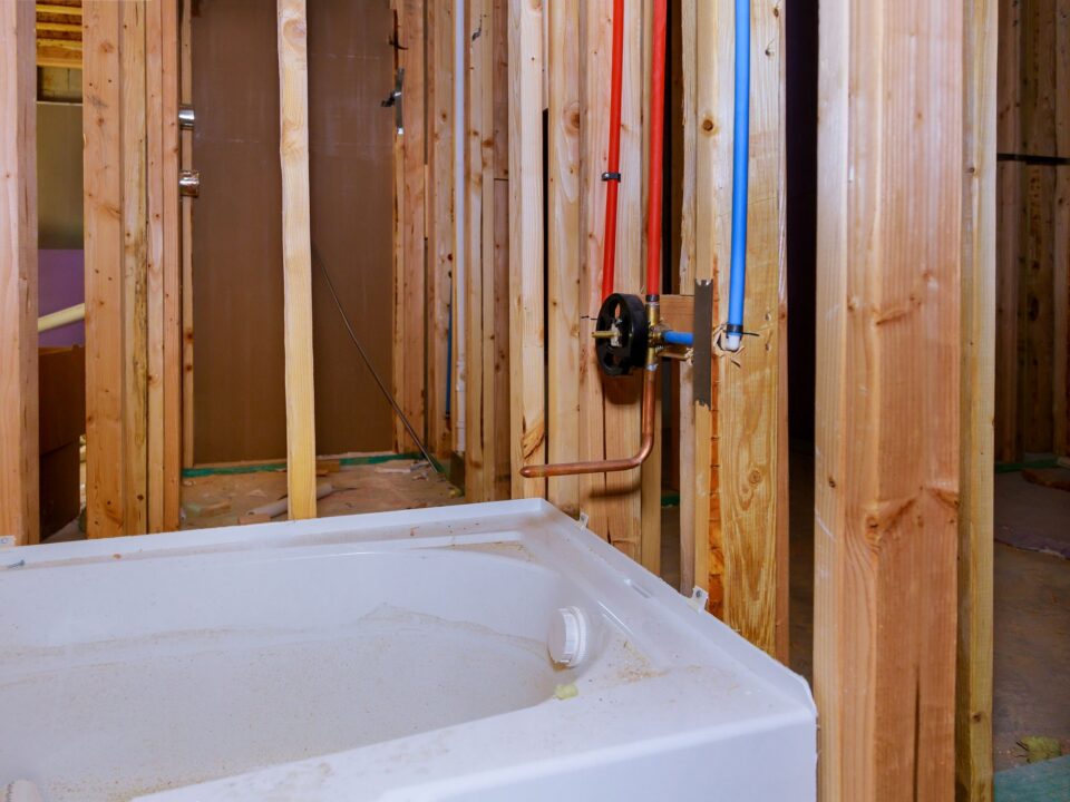 Bathroom mid-renovation with pipework exposed