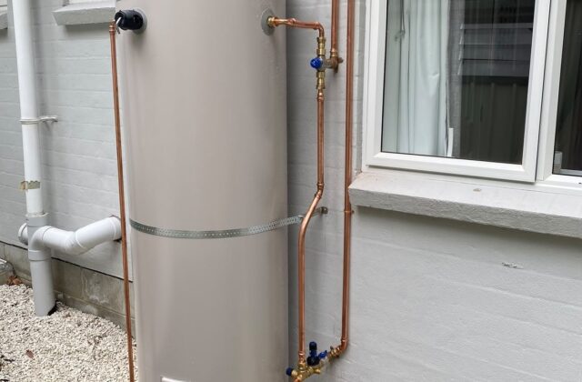 Hot water cylinder installed on an exterior wall