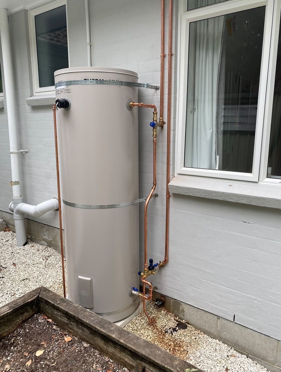 Hot water cylinder installed on an exterior wall