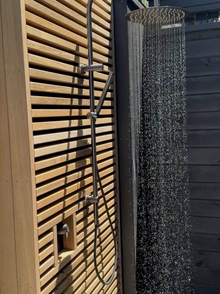 Outdoor shower installed against a house wall