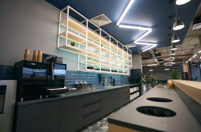 Break room in a modern office with a coffee machine and tiled splashback