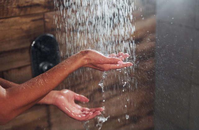 Hands under running water in a shower