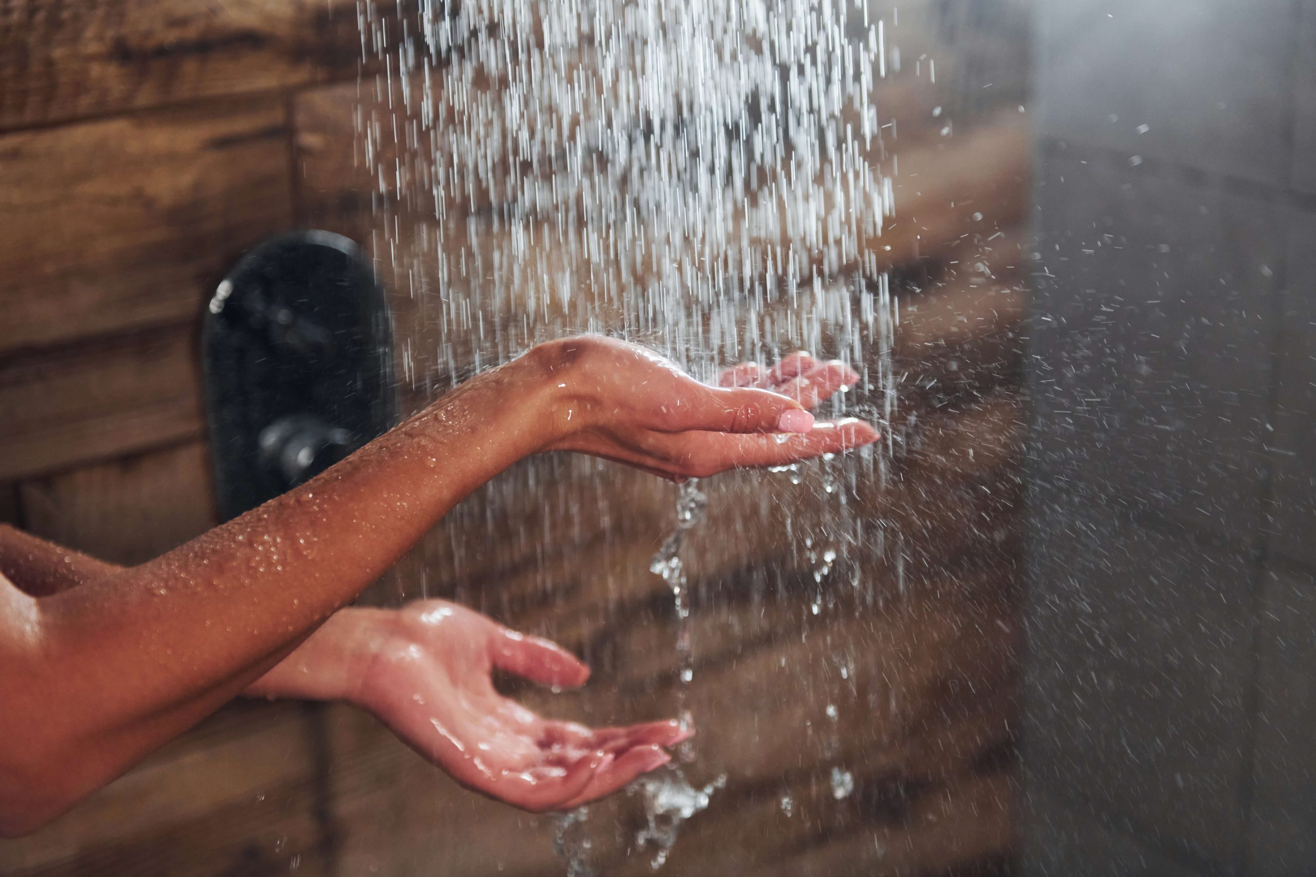 Hands under running water in a shower