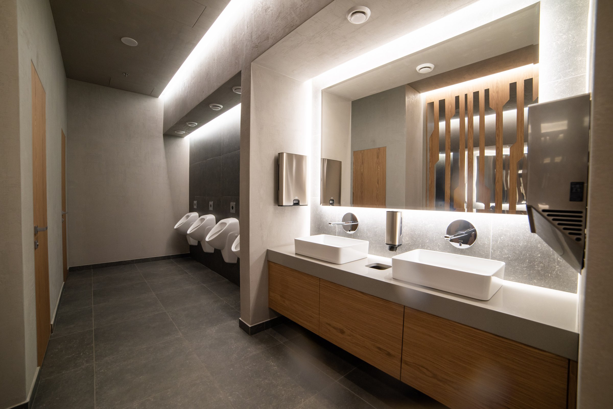 Commercial washroom with a run of basins and urinals